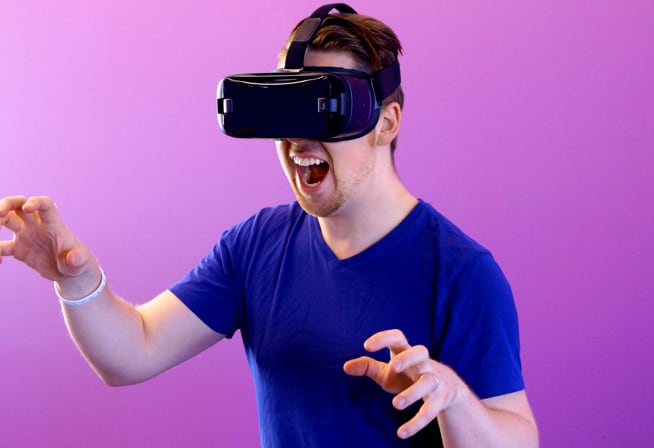 Um homem branco utilizando óculos de realidade virtual